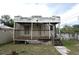 View of the house, showcasing a covered back porch, classic features, and backyard at 1601 Dixie Hwy, Tarpon Springs, FL 34689
