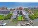 An aerial view of the building shows trees, the waterfront, a swimming pool, docks, boats and a view of the beach at 19531 Gulf Blvd # 611, Indian Shores, FL 33785