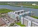 An aerial view of the building and surrounding area shows trees, the waterfront and nearby condos in the area at 19531 Gulf Blvd # 611, Indian Shores, FL 33785