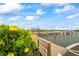 Wooden walkway leading to docks, framed by bright yellow flowering plants at 19531 Gulf Blvd # 611, Indian Shores, FL 33785
