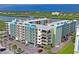 A partial view of the exterior of the building shows a parking lot and trees in front with a waterfront in the background at 19531 Gulf Blvd # 611, Indian Shores, FL 33785