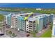A partial view of the exterior of the building shows a parking lot and trees in front with a waterfront in the background at 19531 Gulf Blvd # 611, Indian Shores, FL 33785