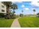 Beautiful lawn and walkway leading to the condo building and boat docks, enhanced by swaying palm trees at 19531 Gulf Blvd # 611, Indian Shores, FL 33785