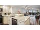 Open kitchen with granite countertops leading to a spacious living room and outside balcony at 19531 Gulf Blvd # 611, Indian Shores, FL 33785