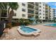 Community hot tub near pool with chairs, umbrellas and lush landscaping at 19531 Gulf Blvd # 611, Indian Shores, FL 33785