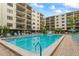 Community pool with plenty of lounge chairs and shade umbrellas at 19531 Gulf Blvd # 611, Indian Shores, FL 33785