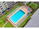 Aerial view of pool with chairs and umbrellas and manicured landscaping at 19531 Gulf Blvd # 611, Indian Shores, FL 33785