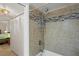 Modern shower with tiled surround, updated fixtures, and convenient shelves at 19531 Gulf Blvd # 611, Indian Shores, FL 33785