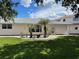 Beautiful backyard with a lush lawn, tropical trees, and white gravel, great for landscaping at 20971 Negril Ct, Lutz, FL 33558