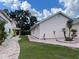 Side view of home showing mature landscaping, manicured lawn, and brick sidewalk at 20971 Negril Ct, Lutz, FL 33558