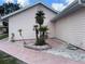Exterior view of home with mature tropical landscaping, including rocks and brick at 20971 Negril Ct, Lutz, FL 33558