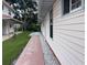 Brick sidewalk leading along the side of the house, well manicured lawn, and gravel at 20971 Negril Ct, Lutz, FL 33558
