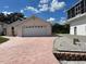 Pink home with two-car garage, driveway, and lush landscaping at 20971 Negril Ct, Lutz, FL 33558