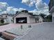 Detached garage with white car, brick driveway and decorative rocks for enhanced curb appeal at 20971 Negril Ct, Lutz, FL 33558