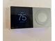 Smart thermostat displaying 75 degrees and 60% humidity enhancing comfort and energy efficiency at 20971 Negril Ct, Lutz, FL 33558