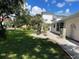 Landscaped yard featuring tropical plants and a well-maintained lawn, enhancing the property's curb appeal at 20971 Negril Ct, Lutz, FL 33558