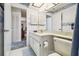 Bathroom includes a toilet, vanity, a sink, and white cabinets for storage at 2183 Westchester Blvd, Spring Hill, FL 34606