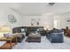 Spacious living room with plush gray carpeting, featuring a large leather sofa set at 2183 Westchester Blvd, Spring Hill, FL 34606