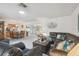 Open-concept living area with plush gray carpeting, features a large leather sofa set and dining table at 2183 Westchester Blvd, Spring Hill, FL 34606