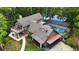 Aerial view of the home featuring a screen enclosed pool, patio, balconies, and lush surrounding trees at 2202 Amity Ct, New Port Richey, FL 34655