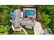 Aerial view of property with screened pool, lush landscaping, and charming exterior at 2202 Amity Ct, New Port Richey, FL 34655