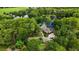 An aerial view of the lush property featuring mature landscaping, a private pool, and tranquil pond at 2202 Amity Ct, New Port Richey, FL 34655