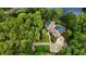 Aesthetic aerial shot of the property featuring mature landscaping, pool, lake, and private yard at 2202 Amity Ct, New Port Richey, FL 34655