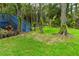 View of the backyard showing a set of painted blue stairs, green lawn, and pond at 2202 Amity Ct, New Port Richey, FL 34655