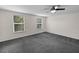 Bright and airy bedroom with new carpet, a ceiling fan, and plenty of natural light from two windows at 2202 Amity Ct, New Port Richey, FL 34655