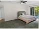 Bedroom features neutral decor, a ceiling fan, and a glass sliding door to an outdoor deck at 2202 Amity Ct, New Port Richey, FL 34655