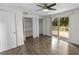Bedroom with hardwood floors, open closets, ceiling fan, and a sliding door to deck at 2202 Amity Ct, New Port Richey, FL 34655