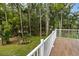 Back deck with white railing overlooks lush greenery, creating a peaceful outdoor space at 2202 Amity Ct, New Port Richey, FL 34655