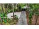 View of the lush landscape, gate, and long private driveway from the entrance of the property at 2202 Amity Ct, New Port Richey, FL 34655