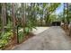 View of the lush landscape, gate, and long private driveway from the entrance of the property at 2202 Amity Ct, New Port Richey, FL 34655
