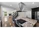 Gourmet kitchen featuring black cabinets, stainless steel appliances, large granite island with cooktop and open floor plan at 2202 Amity Ct, New Port Richey, FL 34655
