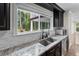 A close up of the Kitchen Sink area with granite countertops, stainless steel appliances and a window with views of the outdoors at 2202 Amity Ct, New Port Richey, FL 34655