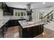 Stunning kitchen features an island cooktop, granite counters, and black cabinetry, enhanced by stainless steel appliances at 2202 Amity Ct, New Port Richey, FL 34655