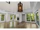 Bright living room with a wood floor, large windows showcasing natural light, and a fireplace with decorative tile at 2202 Amity Ct, New Port Richey, FL 34655