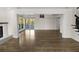 Open-concept living room with wood flooring, sliding glass doors, and modern light fixture at 2202 Amity Ct, New Port Richey, FL 34655