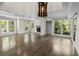 Spacious living room featuring hard wood floor, fireplace and large windows offering lush outdoor views and natural light at 2202 Amity Ct, New Port Richey, FL 34655