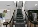 Carpeted staircase with stained handrails and spindels leading to an upper level at 2202 Amity Ct, New Port Richey, FL 34655