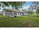 A well-maintained backyard with green grass, a chain-link fence, and a stylish fire pit area, perfect for entertaining at 2251 Evenglow Ave, Spring Hill, FL 34609