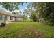 Large backyard features a well-maintained lawn and fire pit area at 2251 Evenglow Ave, Spring Hill, FL 34609