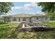The backyard features a fire pit, lush grass, and a view of the home's rear exterior, offering a serene outdoor space at 2251 Evenglow Ave, Spring Hill, FL 34609