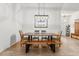 Open dining room with a rustic wooden table and bench seating under an industrial light fixture at 2251 Evenglow Ave, Spring Hill, FL 34609