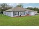 Charming single-story home with a well-manicured lawn, and lush flowerbeds enhancing its curb appeal at 2251 Evenglow Ave, Spring Hill, FL 34609
