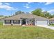 Charming single-story home with a well-manicured lawn and lush flowerbeds enhancing its curb appeal at 2251 Evenglow Ave, Spring Hill, FL 34609