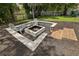 Stylish backyard fire pit surrounded by seating and wooden steps, perfect for outdoor gatherings and cozy evenings at 2251 Evenglow Ave, Spring Hill, FL 34609