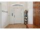 Bright foyer with tile flooring, coat rack, and shelf with shoe storage, bench, and well-lit entry at 2251 Evenglow Ave, Spring Hill, FL 34609