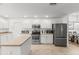Bright kitchen features white cabinets, stainless steel appliances, and an island for extra counter space at 2251 Evenglow Ave, Spring Hill, FL 34609